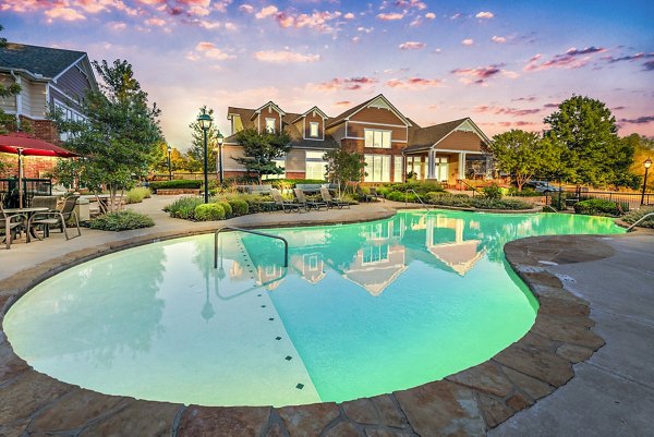 Resort-style pool with lounge chairs at Aventura Clear Creek Apartments