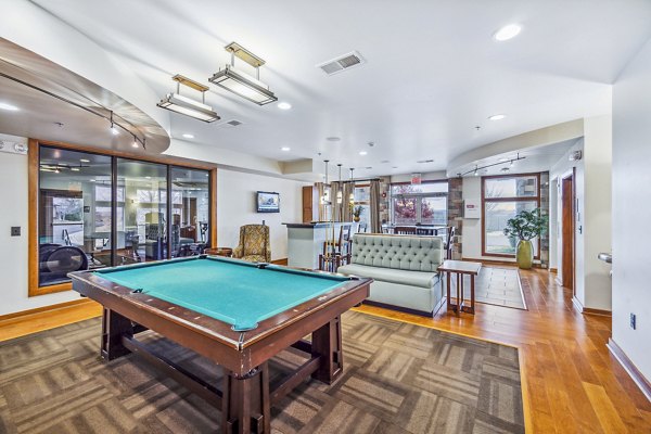 Clubhouse game room with pool table and large-screen TVs at Aventura Falcon Valley Apartments, offering luxury entertainment spaces
