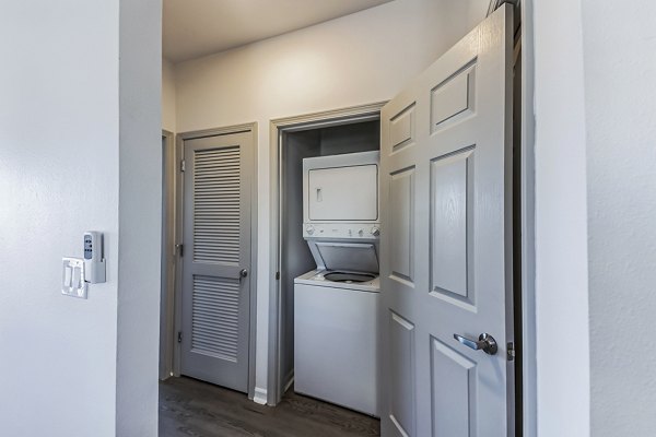 Laundry room with modern washers and dryers at Aventura Falcon Valley Apartments