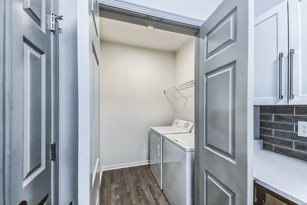 Modern laundry room with energy-efficient washers at Aventura Falcon Valley Apartments