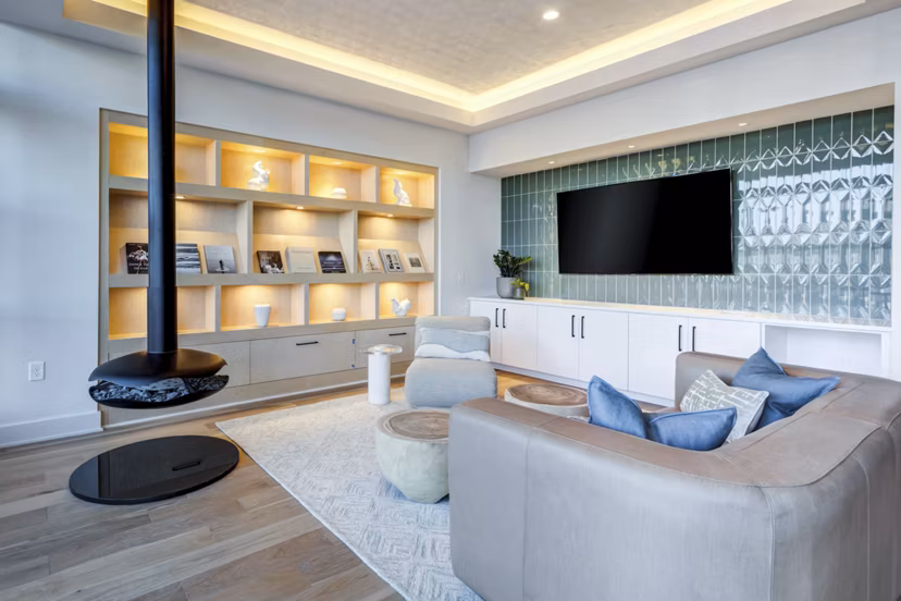 Modern clubhouse with lounge seating and large-screen TVs at Ello House Apartments