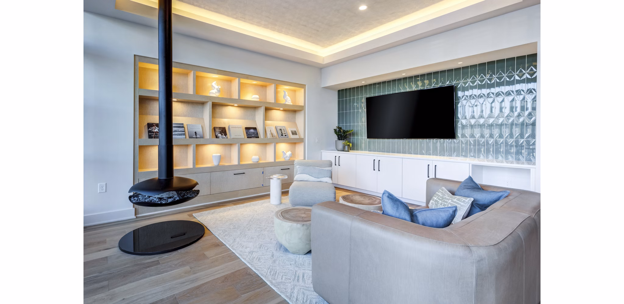 Modern clubhouse with lounge seating and large-screen TVs at Ello House Apartments