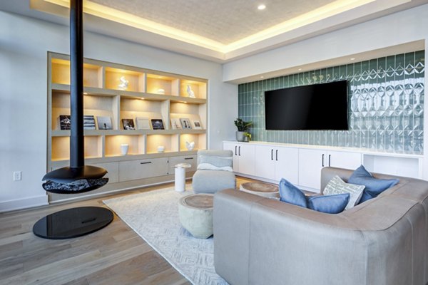 Modern clubhouse with lounge seating and large-screen TVs at Ello House Apartments