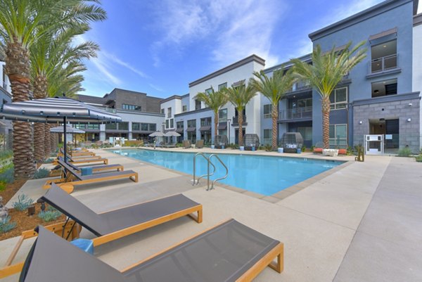 Modern pool with lounge chairs at Persea Apartments, offering a relaxing amenity for residents seeking luxury living