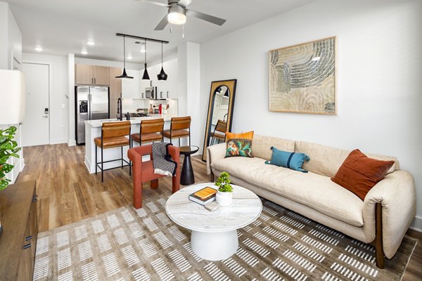 Spacious living room featuring modern decor and large windows at Rye Charlotte Ave Apartments, offering luxury living