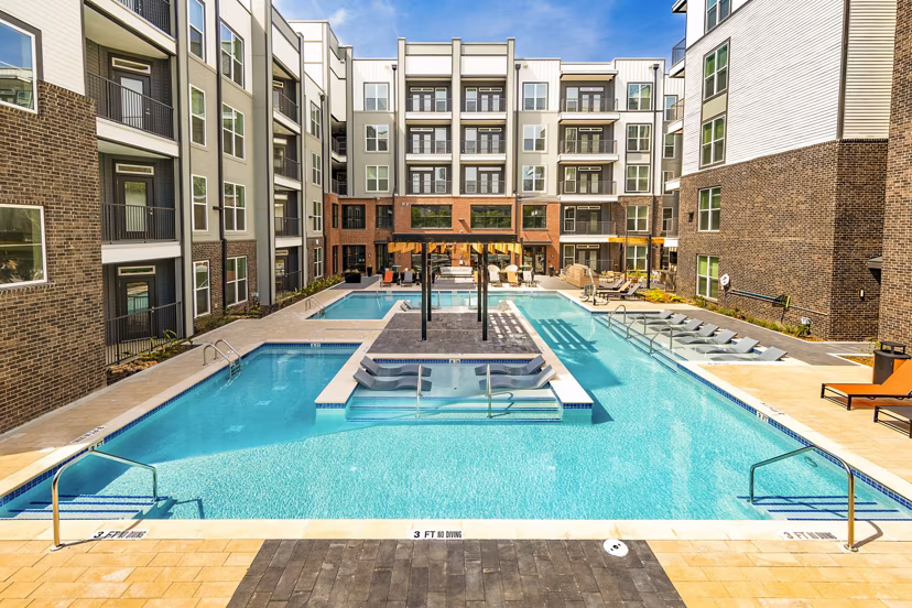 Elegant outdoor pool area at Rye Charlotte Ave Apartments with luxurious poolside seating and landscaping