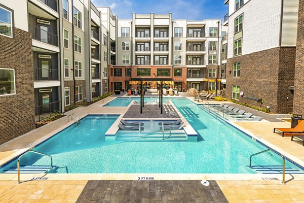 Elegant outdoor pool area at Rye Charlotte Ave Apartments with luxurious poolside seating and landscaping