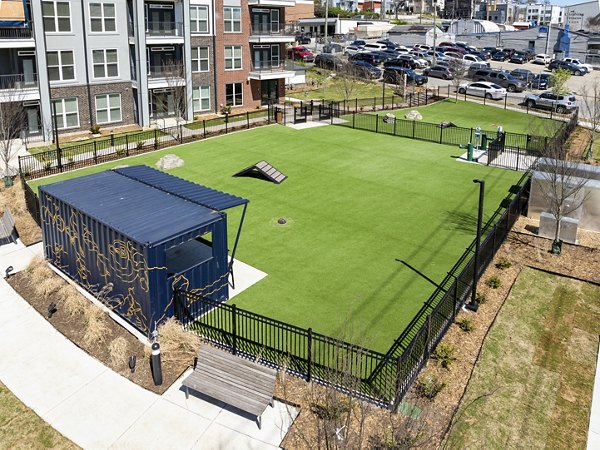 Dog park area with artificial grass, benches, and agility equipment at luxury apartments