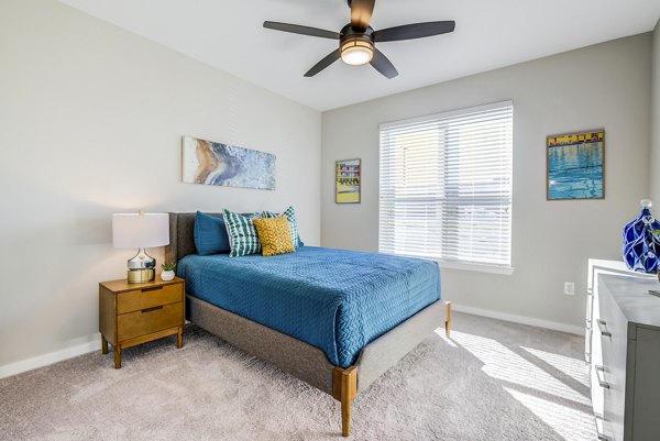 Cozy bedroom with stylish decor at The Pointe at Siena Ridge Apartments in luxury setting