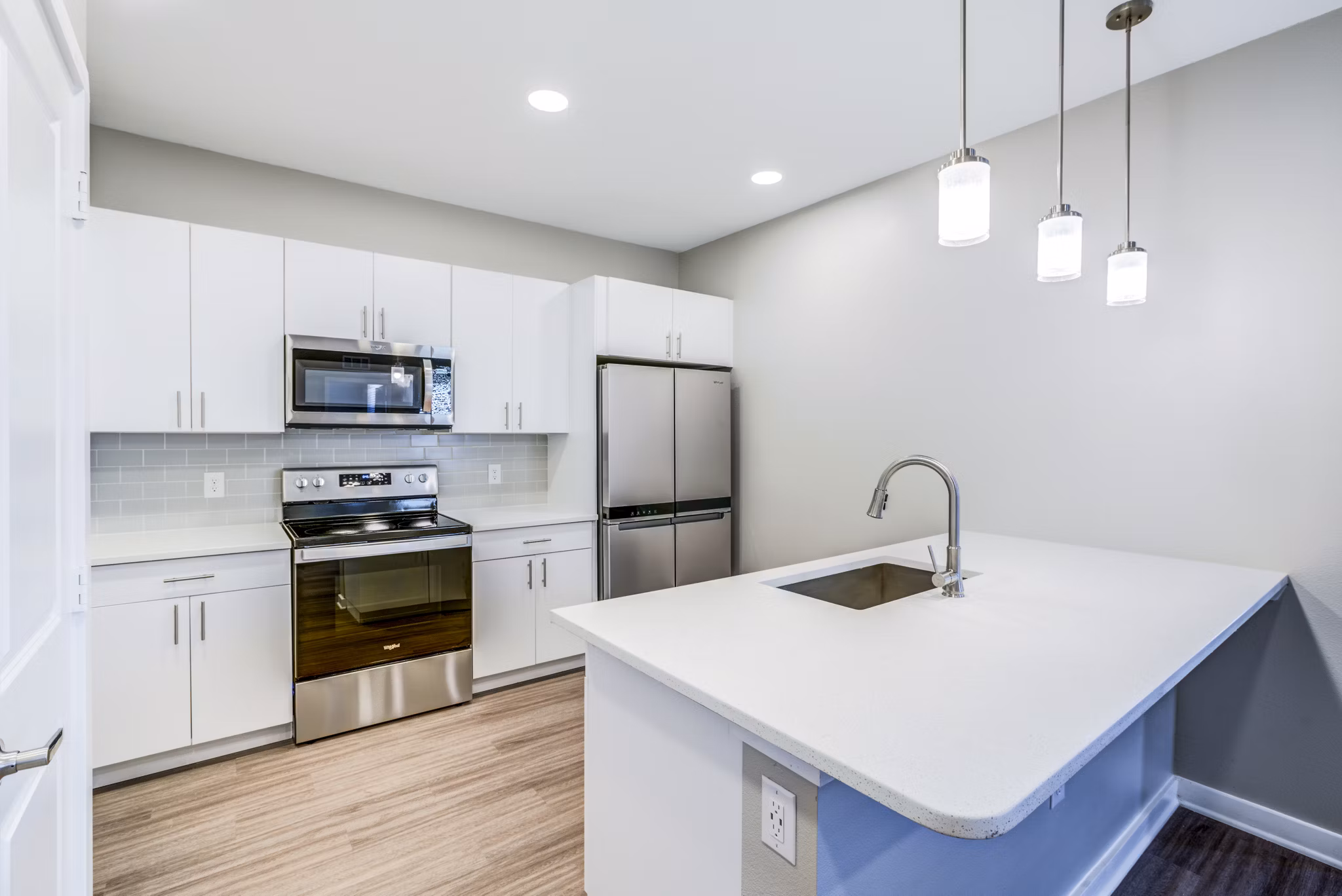 Modern kitchen with stainless steel appliances and island at The Pointe at Siena Ridge Apartments