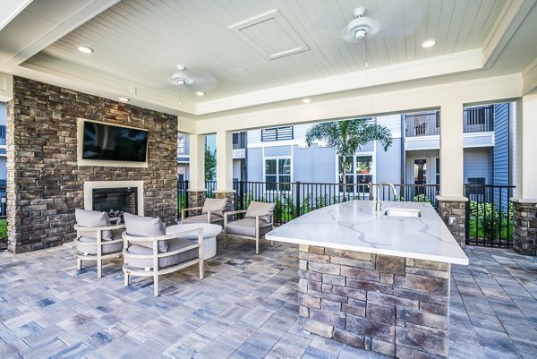 Fire pit patio with comfortable seating at The Pointe at Siena Ridge Apartments