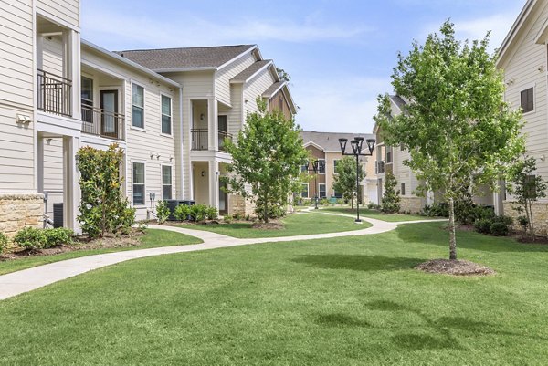 Reserve at Lake Jackson: Contemporary apartment building set against lush greenery in Lake Jackson, Texas