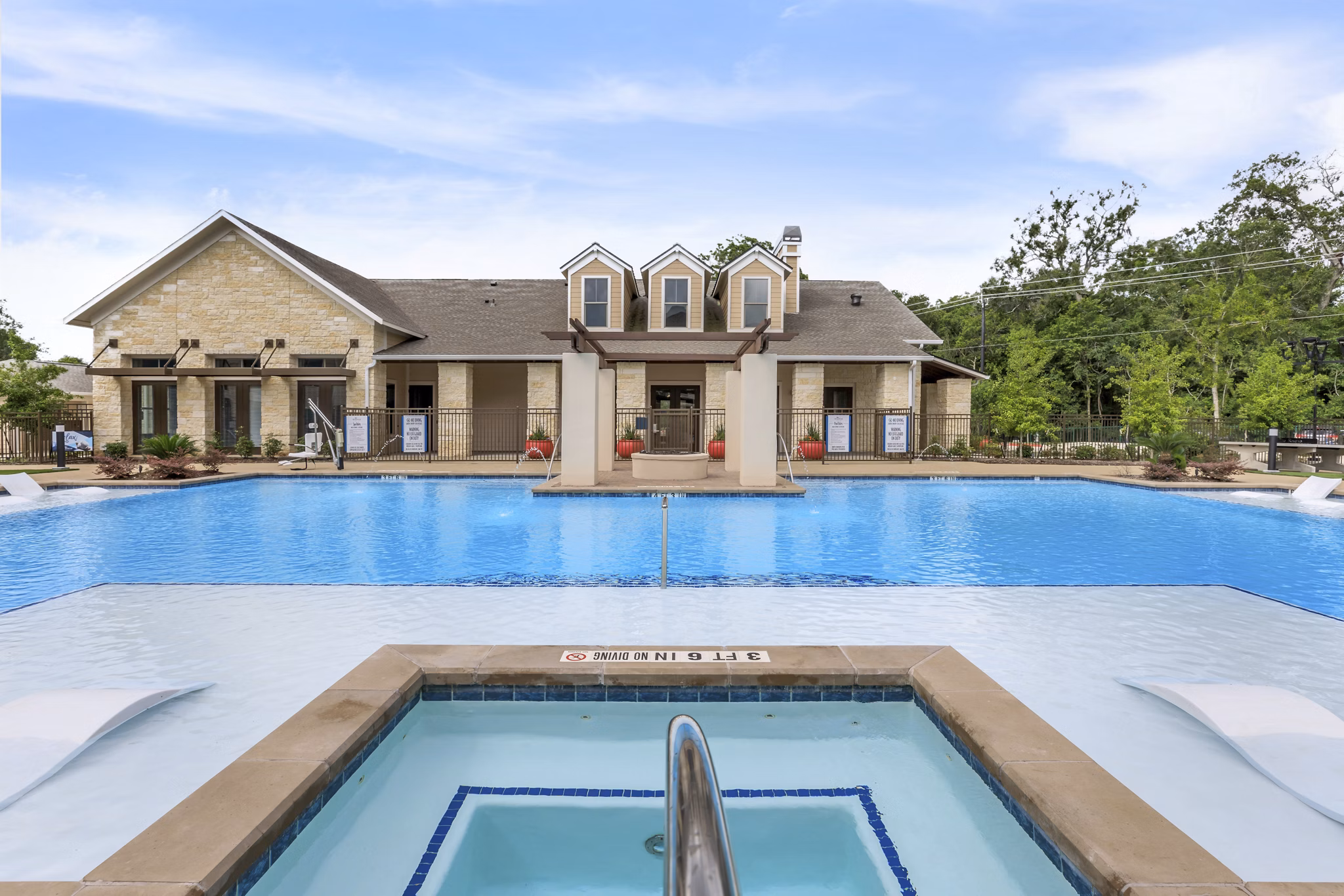 Resort-style pool area with lounge seating at Reserve at Lake Jackson Apartments