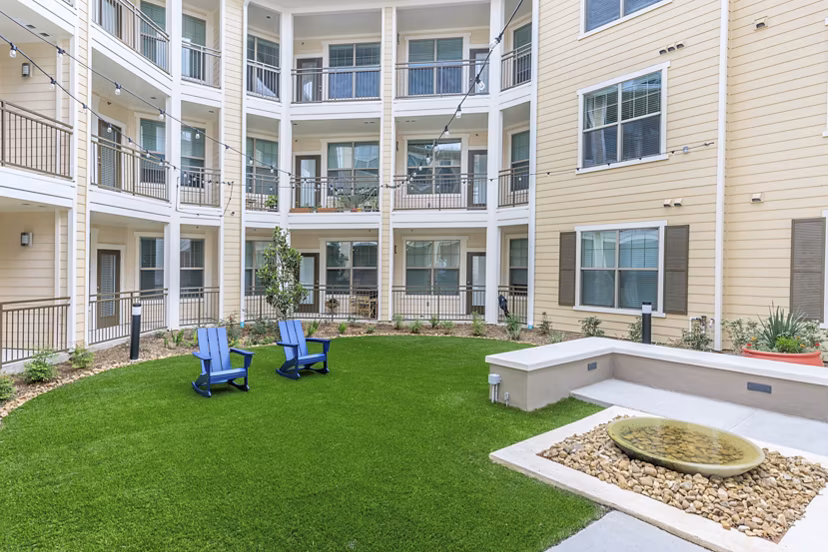 Courtyard featuring lush landscaping at Reserve at Lake Jackson Apartments, luxurious community amenities for relaxation and socializing
