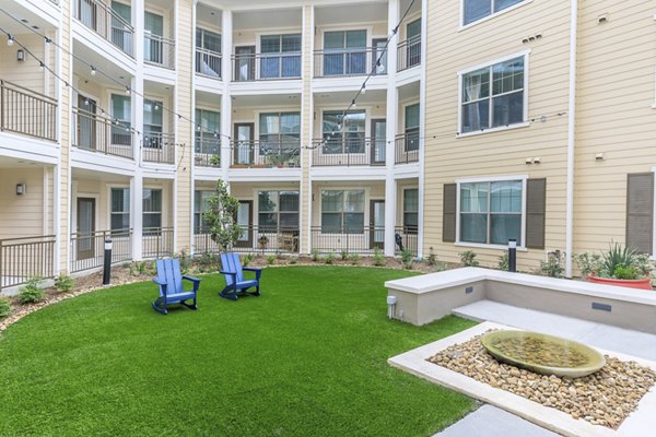 Courtyard featuring lush landscaping at Reserve at Lake Jackson Apartments, luxurious community amenities for relaxation and socializing