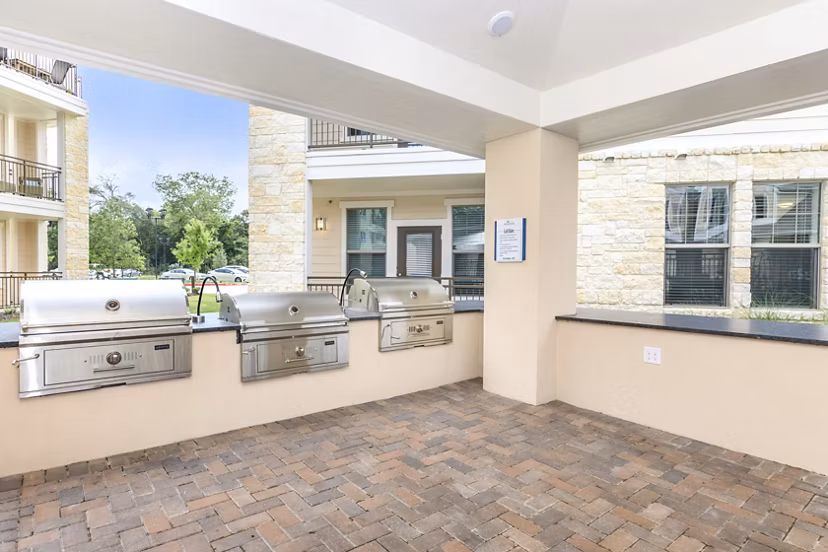 Outdoor grill area with modern seating at Reserve at Lake Jackson Apartments