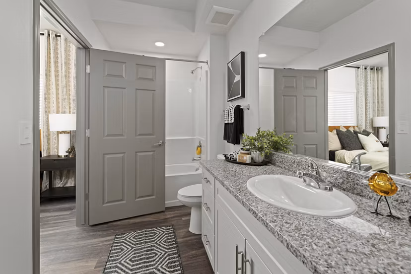 Luxurious bathroom with marble countertops and glass shower at Cardinal 95 Apartments