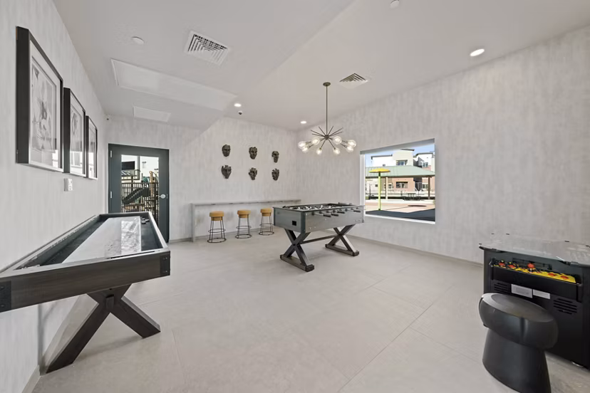 Game room with pool table and flat-screen TVs at Cardinal 95 Apartments