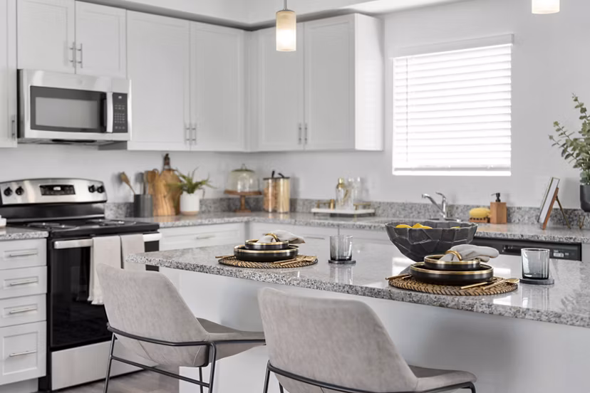 Modern kitchen with stainless steel appliances and marble countertops at Cardinal 95 Apartments