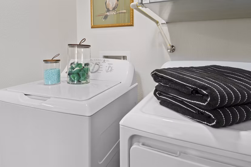 Laundry room equipped with modern machines at Cardinal 95 Apartments