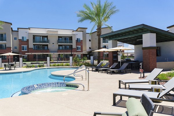 Resort-style pool at Cardinal 95 Apartments with modern lounge seating and lush landscaping, perfect for relaxation and leisure activities