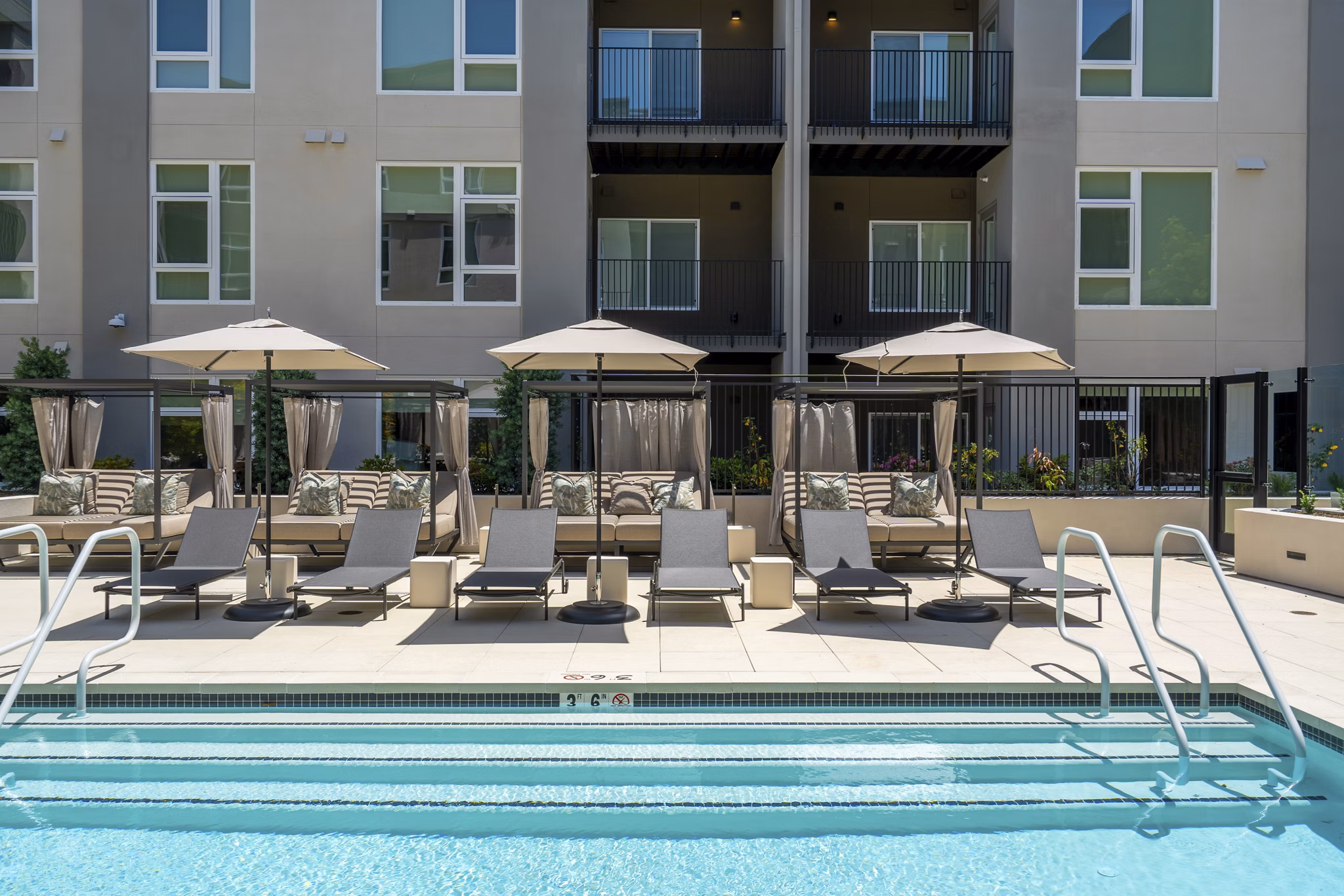 Modern outdoor pool with lounge chairs at The Hayden Apartments