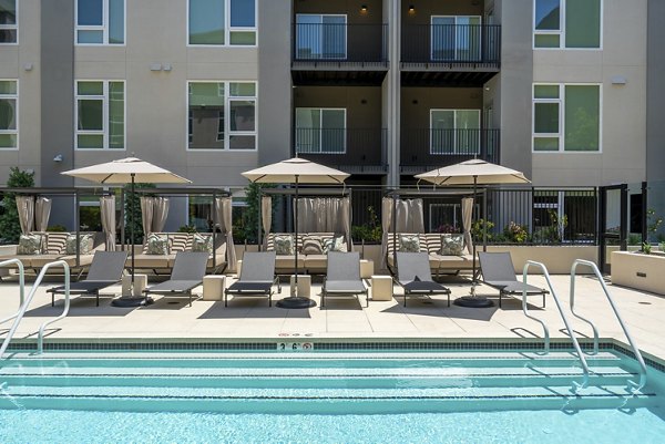 Modern outdoor pool with lounge chairs at The Hayden Apartments