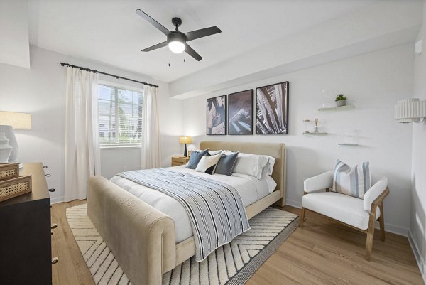 Cozy bedroom with modern decor at Elan Polo Gardens Apartments, featuring elegant lighting and ample natural light