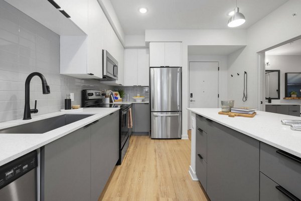 Modern kitchen with stainless steel appliances at Elan Polo Gardens Apartments