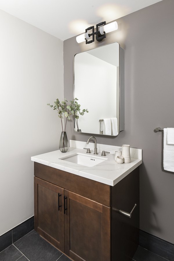 Modern bathroom featuring dual vanities and minimalist fixtures at Hagert and York Apartments