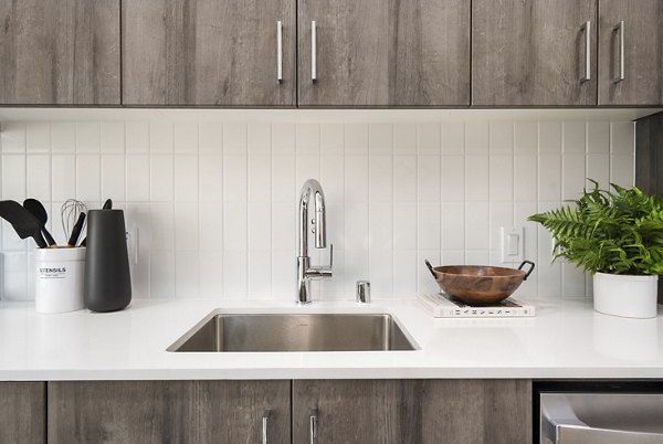 Modern kitchen with stainless steel appliances and marble countertops in Ventana Residences apartments