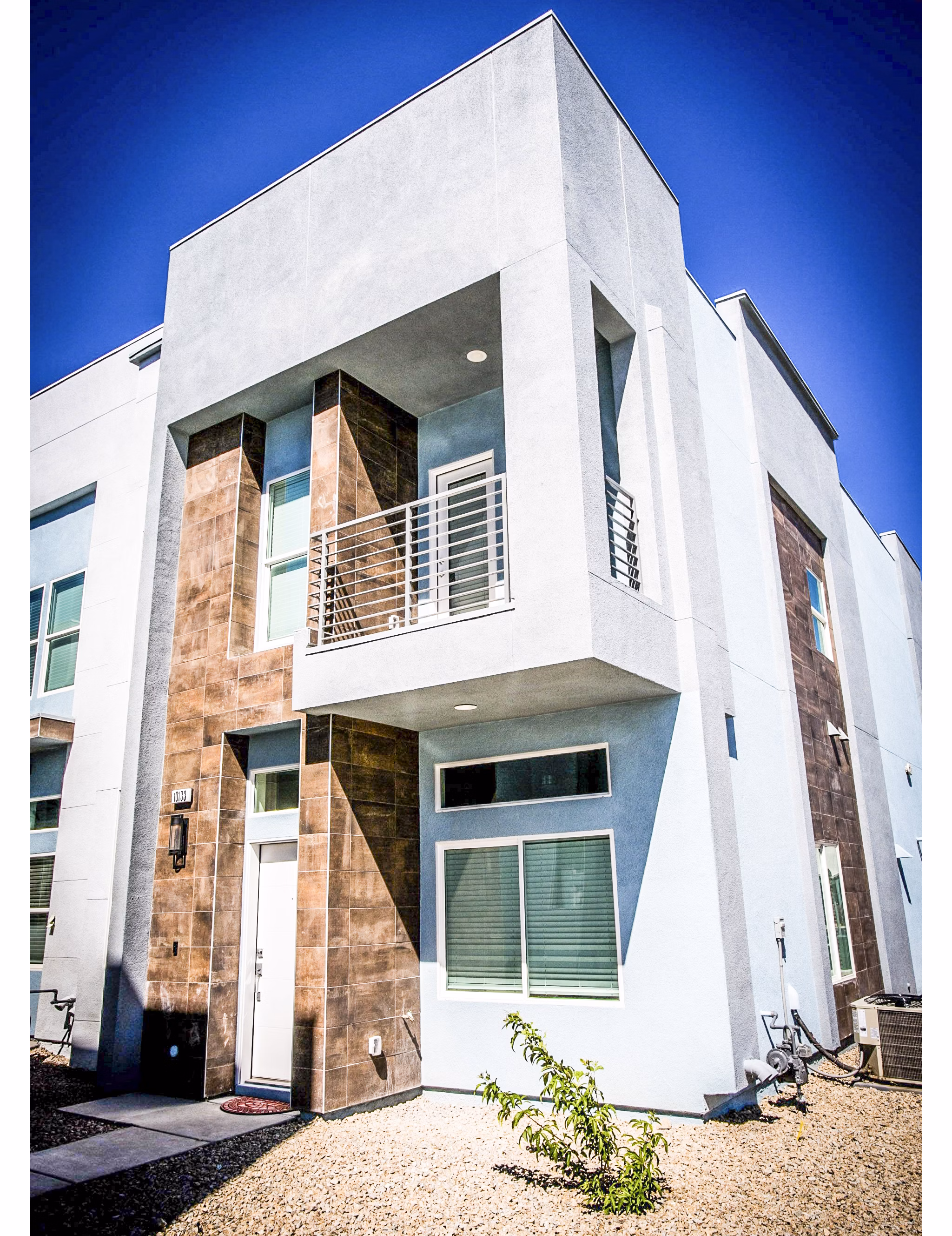 Townes at Peace Way Apartments: Elegant building with lush landscaping, showcasing luxury living in a premier location