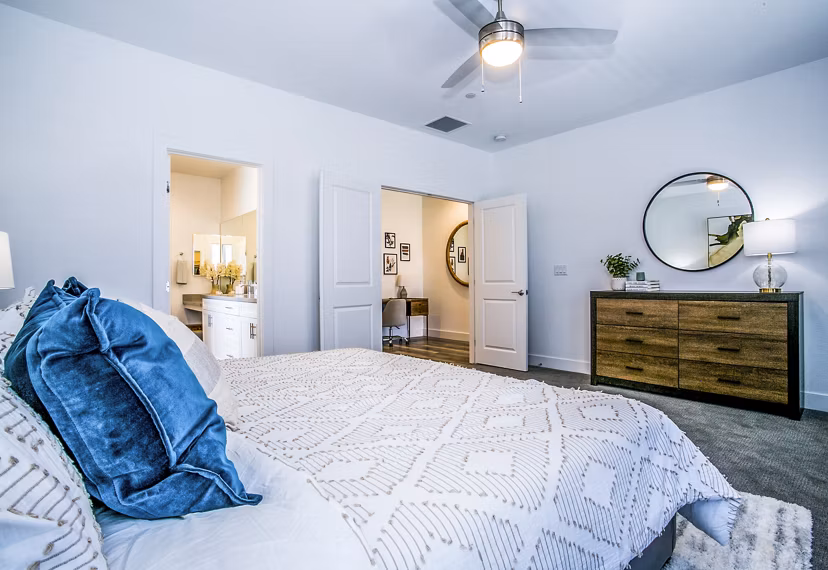 Spacious bedroom with modern decor and large windows at Townes at Peace Way Apartments, luxury living offered by Greystar