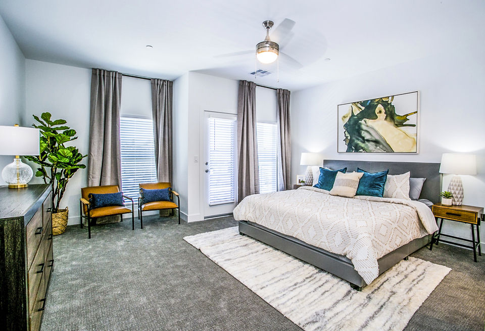 Bedroom with modern decor and natural lighting at Townes at Peace Way Apartments, offering luxury living in Las Vegas