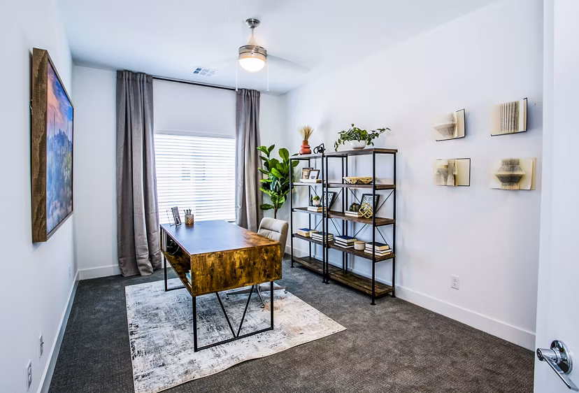 Bright bedroom with versatile home office setup in Townes at Peace Way Apartments