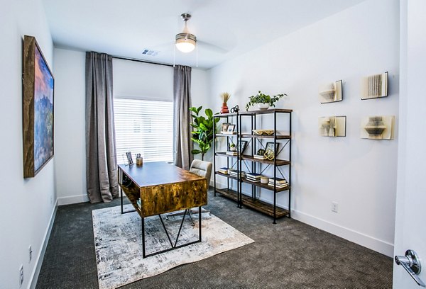 Bright bedroom with versatile home office setup in Townes at Peace Way Apartments
