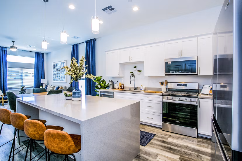 Sleek kitchen featuring stainless steel appliances and granite countertops at Townes at Peace Way Apartments in vibrant community
