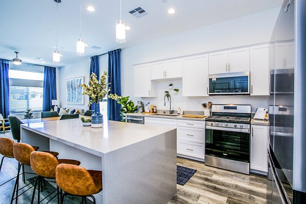 Sleek kitchen featuring stainless steel appliances and granite countertops at Townes at Peace Way Apartments in vibrant community