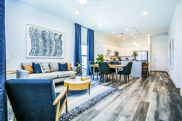 Living room with modern furnishings and natural light at Townes at Peace Way Apartments in luxury setting