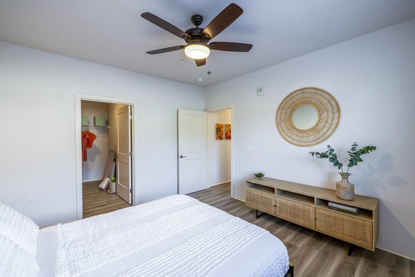 Cozy bedroom featuring stylish decor and ocean-view balcony in Kaulana Mahina Apartments luxury apartments