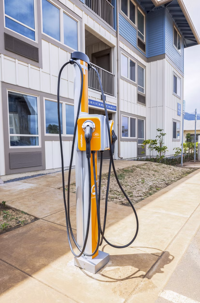 Electric car charging station at Kaulana Mahina Apartments offering sustainable living amenities