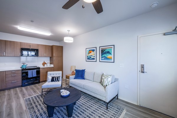 Contemporary living room with sleek furnishings and natural light at Kaulana Mahina Apartments
