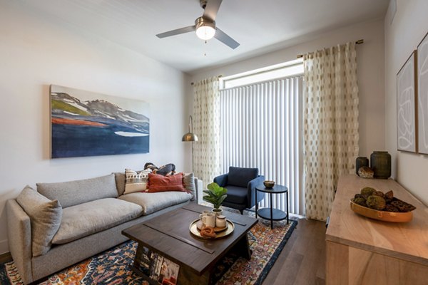 Modern living room with chic decor and large windows at The International at Valley Ranch Apartments