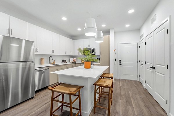 Modern kitchen with granite countertops and stainless steel appliances at Soluna Apartments