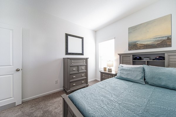 Cozy bedroom with elegant decor at Balcara at Meridiana Homes, featuring plush bedding and modern design elements