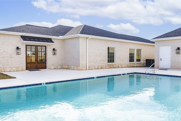 Luxurious pool at Balcara at Meridiana Homes with poolside lounges and scenic views, perfect for relaxation and leisure activities