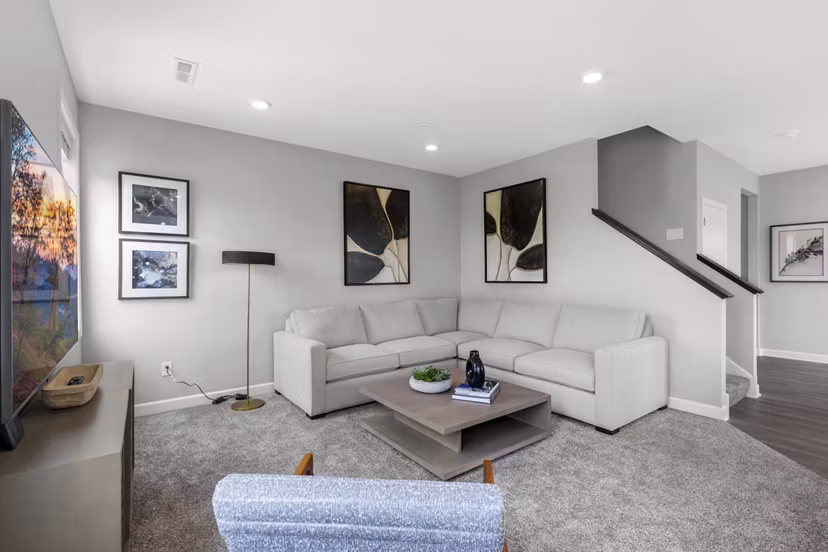 Spacious living room with modern decor and large windows at Bentley Village Apartments