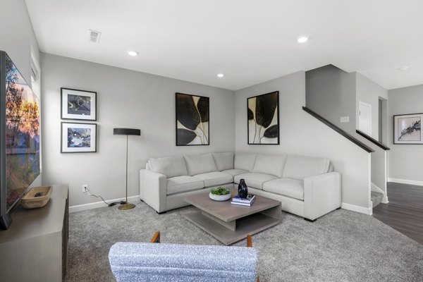 Spacious living room with modern decor and large windows at Bentley Village Apartments