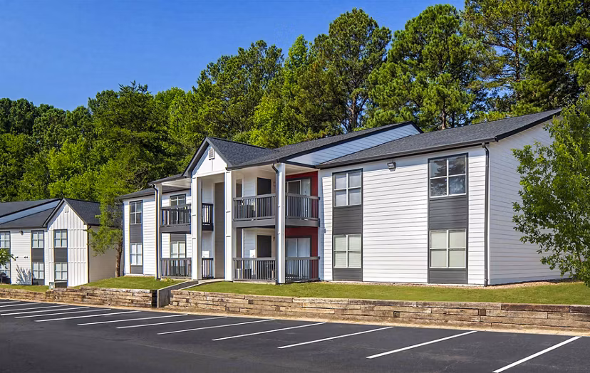 The Oakley Apartments: Stylish mid-rise building surrounded by lush greenery in vibrant city setting