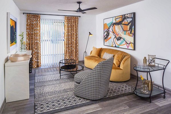 Spacious living room with modern decor in The Oakley Apartments, featuring comfortable seating and natural light